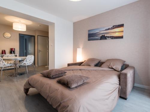 a bedroom with two beds and a dining table at Appart Hôtel Bourgoin in Bourgoin