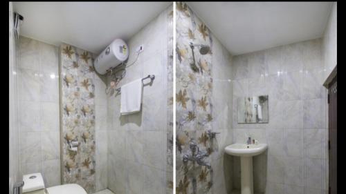 a bathroom with a shower and a toilet and a sink at Aurum Abodes in Hyderabad