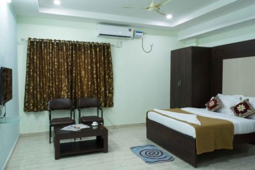 a bedroom with a bed and a chair in it at Aurum Abodes in Hyderabad