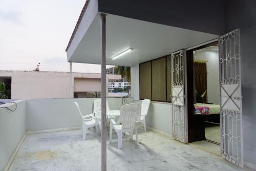 a balcony with a table and chairs and an umbrella at Patel Residency Guest House in Karachi