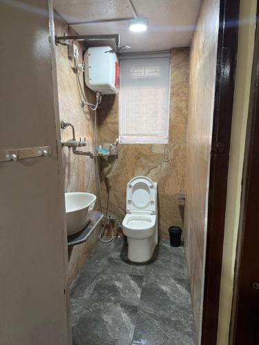 a small bathroom with a toilet and a sink at Mi casa in Kathmandu