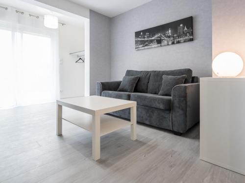 a living room with a couch and a table at Appart Hôtel Bourgoin in Bourgoin