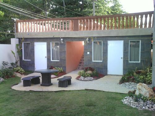 a small house with a deck and a table and benches at Hotel Colombus in Aguada