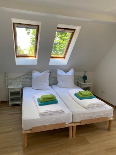 two beds in a room with two windows at Haffquartier - "Zur Alten Bäckerei" in Mönkebude