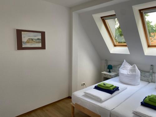 a bedroom with a white bed with two windows at Haffquartier - "Zur Alten Bäckerei" in Mönkebude