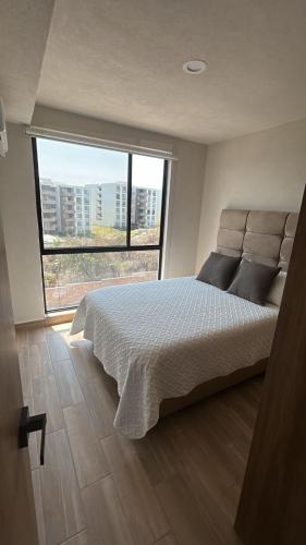 a bedroom with a large bed and a large window at Santa Fe Dorado Atardecer in Atlacholoaya