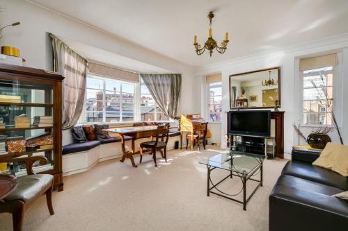 a living room with a couch and a table at Executive Knightsbridge Apartment in London