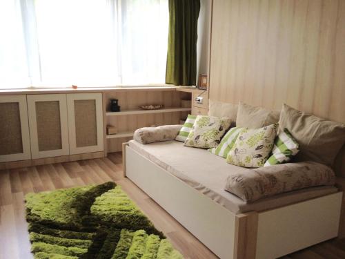 sala de estar con sofá y alfombra verde en Mikes Apartman, en Szekszárd