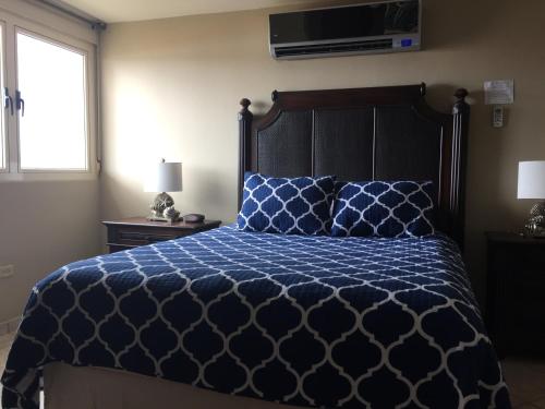 a bedroom with a bed with a blue comforter and a window at Villa 2302 Costa Bonita Beach Resort in Culebra