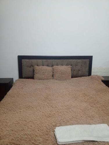 a large bed with a blanket on top of it at Flowers in Jerash