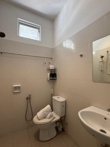 a white bathroom with a toilet and a sink at SPICE Skyview Luxe Tunas 4B3B in Bayan Lepas