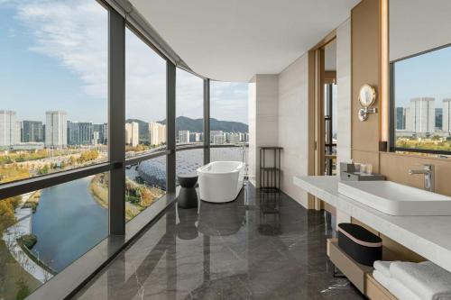 a bathroom with a tub and a view of a river at Deqing Marriott Hotel in Huzhou