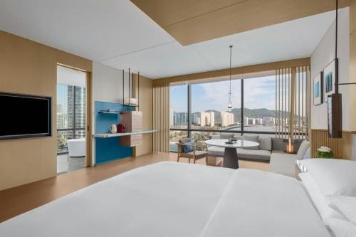 a bedroom with a large bed and a living room at Deqing Marriott Hotel in Huzhou