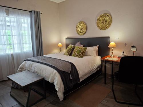 a bedroom with a bed and a desk with two lamps at Altenburgh Accommodation - Apartments in Somerset East