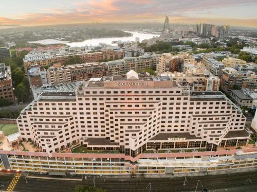 a large hotel building with a view of a city at Novotel Sydney Darling Harbour in Sydney