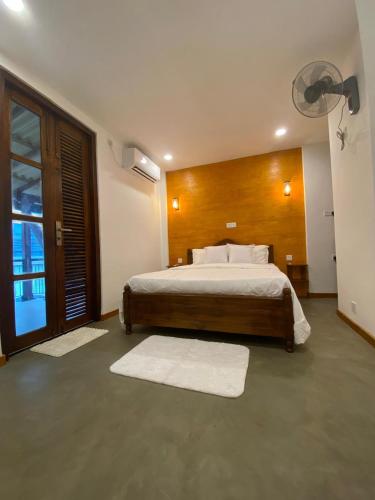 a bedroom with a large bed and a large window at Elite Nest in Ahangama