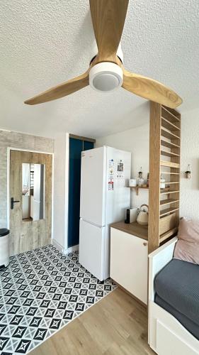 una cucina con ventilatore a soffitto e frigorifero di Les Kikous a Le Grau-du-Roi
