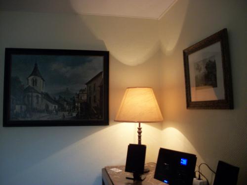 a lamp on a table with a picture on the wall at FILD - Holiday Apartment in Saint-Vith