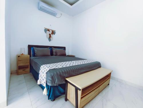 a bedroom with a bed in a white room at Joy Private Pool Villa in Kuta