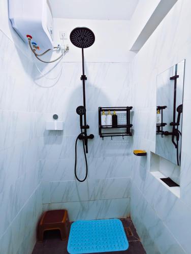 a shower with a blue bench in a white bathroom at Joy Private Pool Villa in Kuta
