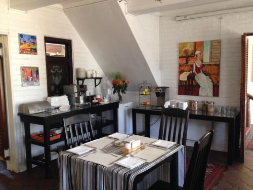 a dining room with a table and chairs and a kitchen at 3 Liebeloft Guest House in Edenvale