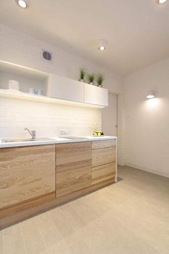 a kitchen with wooden cabinets and a sink at Dom Wakacyjny Solano in Ustka