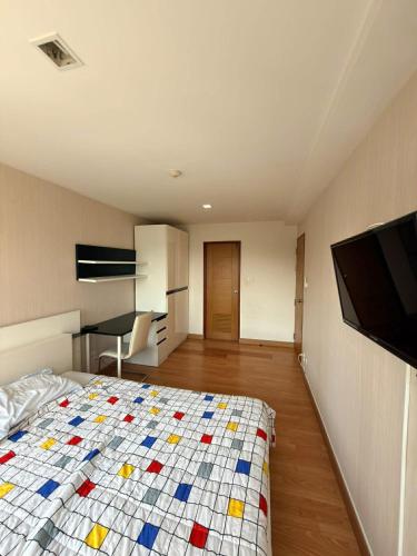 a bedroom with a bed with a colorful quilt at Comfort Big condo in Chiang Mai