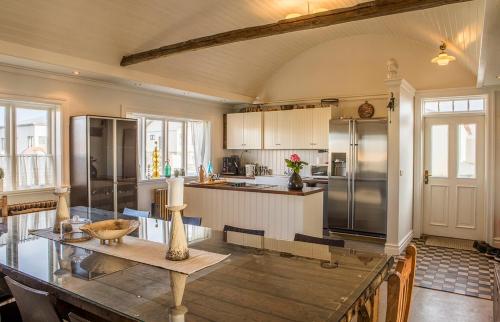 a kitchen with a wooden table and a kitchen with a refrigerator at Merkigil Gisting in Eyrarbakki