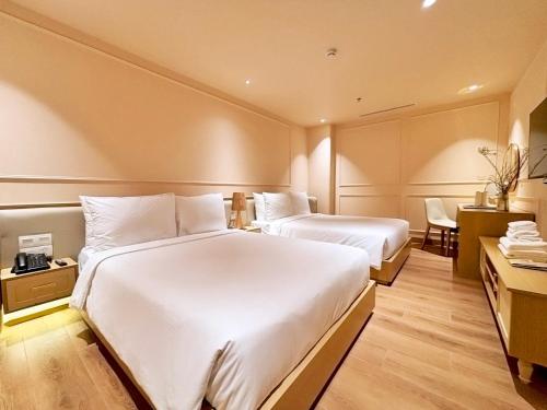 a hotel room with two beds and a desk at Peace Home Boutique Hotel in Phan Thiet