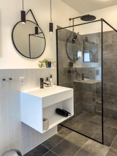 a bathroom with a sink and a shower at Seaside Retreat & Hotel in Stege
