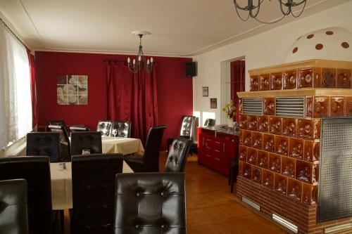 a dining room with red walls and black chairs at Landpension Bielatal - Raum in Raum