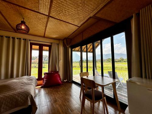 a bedroom with a bed and a table and chairs at Baan Porhdoi Goidao in Chiang Dao