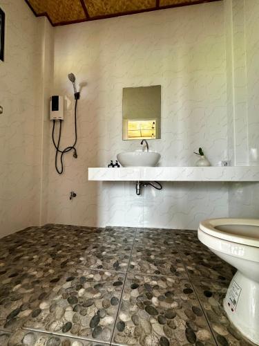 a bathroom with a sink and a toilet at Baan Porhdoi Goidao in Chiang Dao