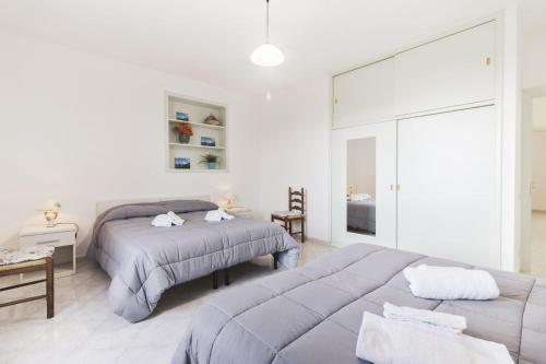 a white bedroom with two beds and a table at Scala Center big holiday house in Scala