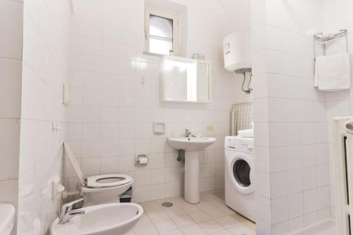 a bathroom with a toilet and a sink and a washing machine at Scala Center big holiday house in Scala