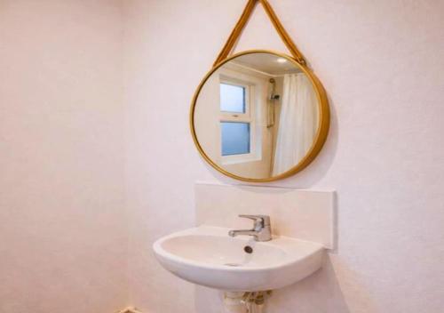 a bathroom with a sink and a mirror on the wall at Matchday Mile House Walk to Anfield sleeps 8 in Liverpool