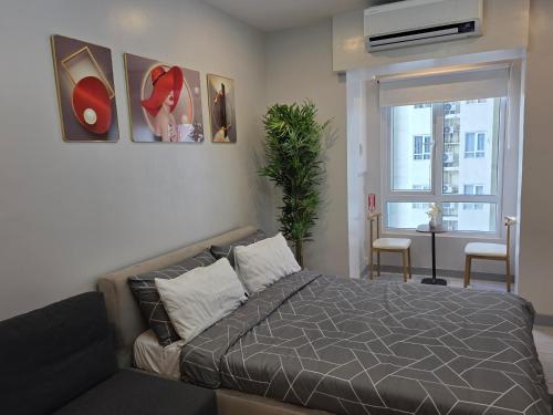 a bedroom with a bed and paintings on the wall at Apartment 2 Quezon City Condo Pool View in Manila
