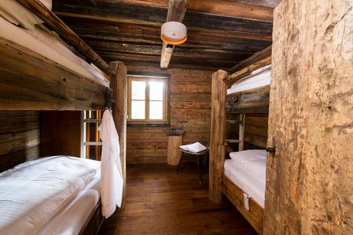 two bunk beds in a room with wooden walls at Wuidererhüttn, Charlet in Alleinlage mit freistehendem Saunahaus in Großkirchheim