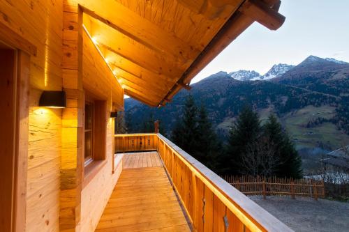 a balcony of a wooden house with mountains in the background at Wuidererhüttn, Charlet in Alleinlage mit freistehendem Saunahaus in Großkirchheim