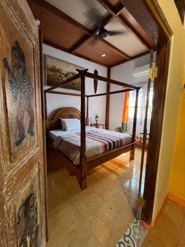 a bedroom with a canopy bed in a room at Amelia Villa in Montongbuwoh