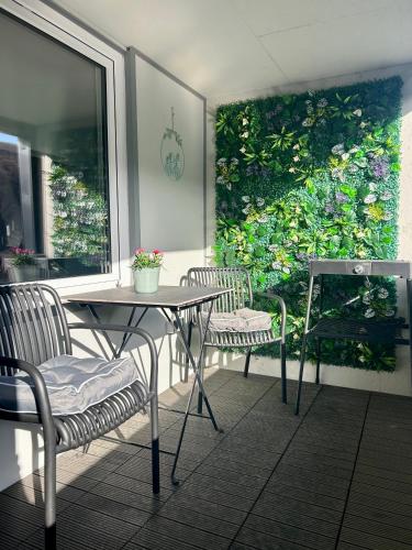 a patio with a table and chairs and a plant wall at Home Ida in Klotten