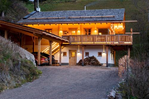 ein Haus mit einer Terrasse und einem Auto vor dem Haus in der Unterkunft Wuidererhüttn in Großkirchheim