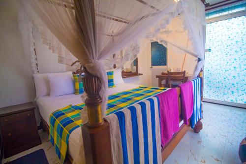 a bedroom with a bed with a canopy at Suriya Homestay Mirissa in Mirissa