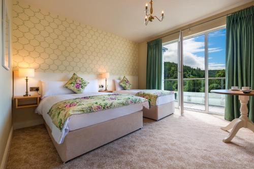 een slaapkamer met 2 bedden en een groot raam bij Woodenbridge Hotel in Arklow