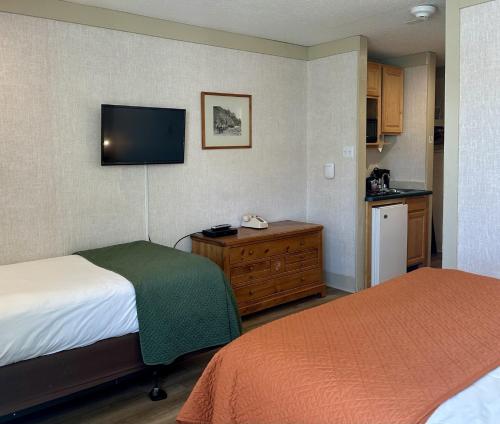 a hotel room with two beds and a kitchen at Mountainside Inn 115 by Alpine Lodging Telluride in Telluride