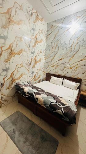 a bed in a room with a marble wall at Hotel Indian Lemon Tree in Jīnd