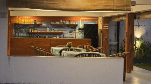 a restaurant with tables and chairs and a bar at Lausanne villa in Dharga Town