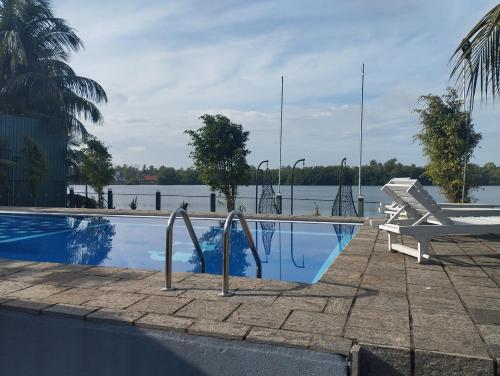 a swimming pool next to a body of water at Lausanne villa in Dharga Town