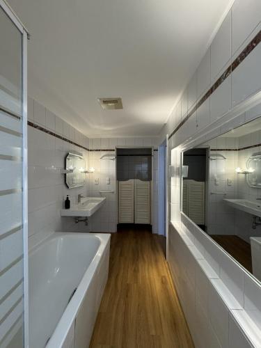 a white bathroom with two sinks and a tub at rooms11 in Salzburg