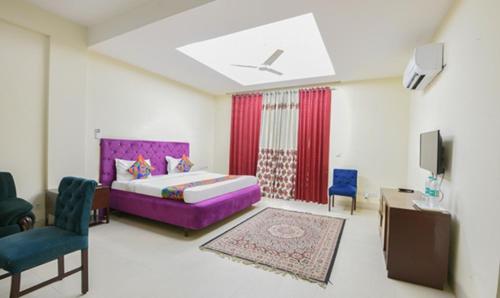 a bedroom with a purple bed and a tv at The Hotel Am Bliss in Gurgaon